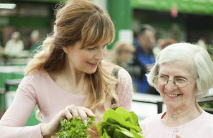 une femme aide une autre au marché